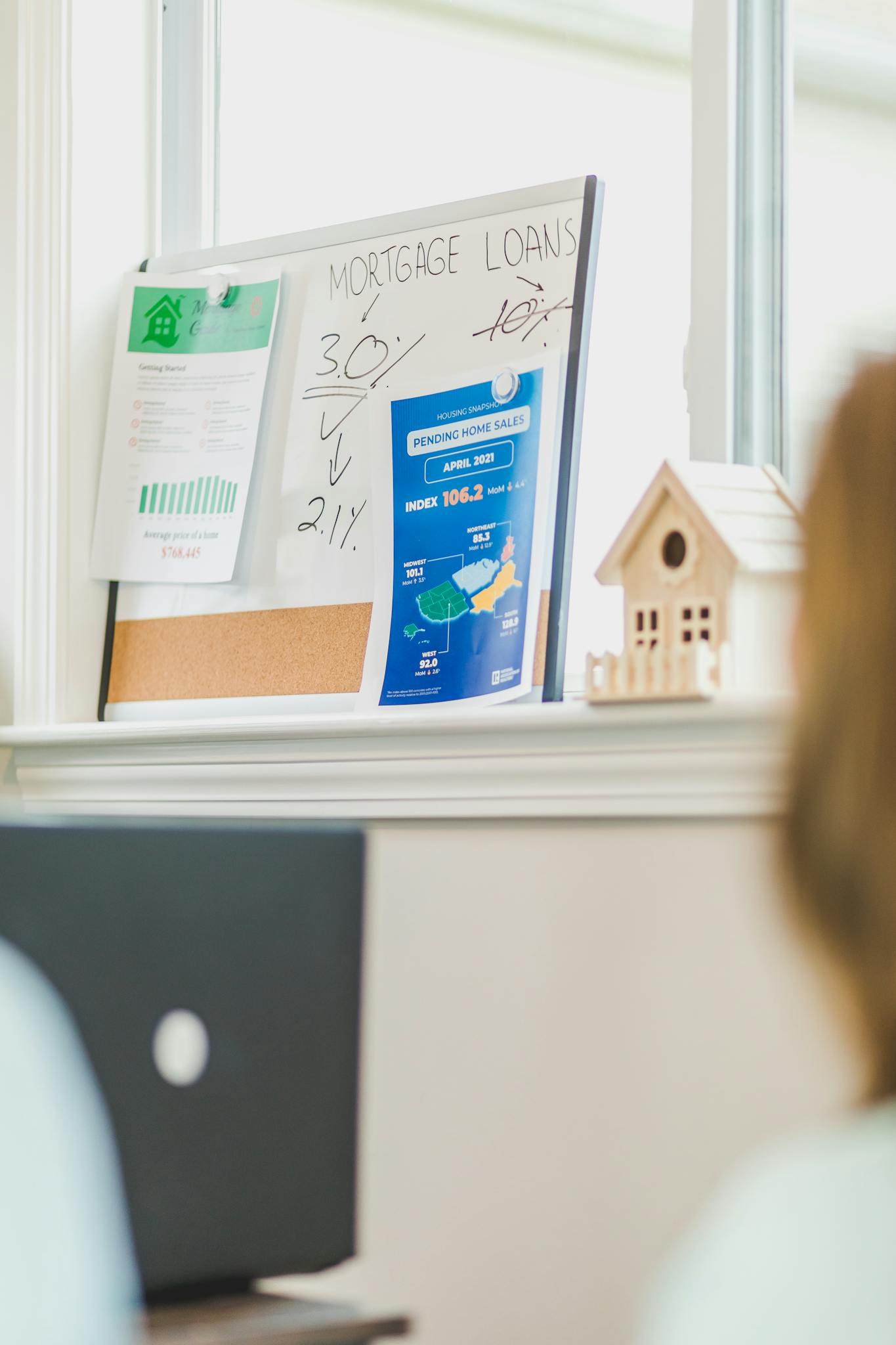 Financial board with mortgage rates and home sales data in a bright office.